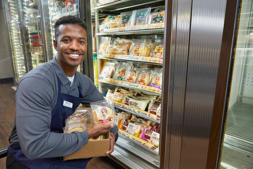 Man stocking convenience store refrigerators